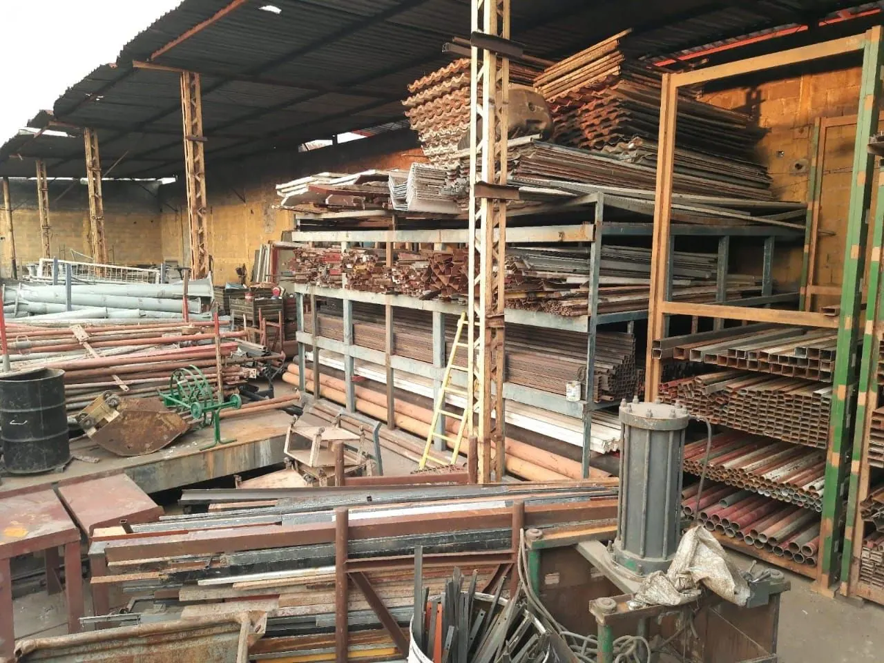 Galpão industrial com estruturas, perfis e equipamentos metálicos retirados pela Rochafer