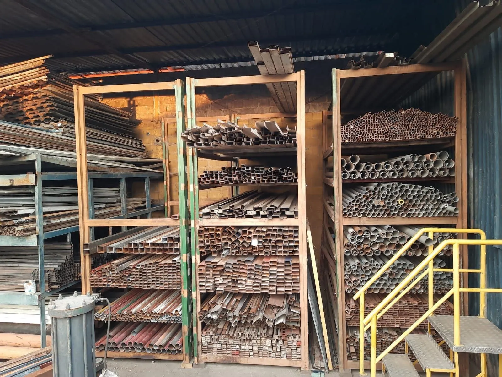 Racks com tubos, metalons e perfis usados organizados por bitola no estoque da Rochafer